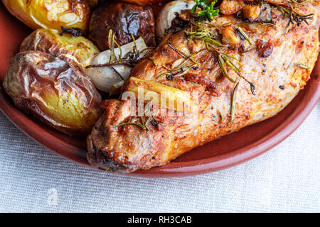 Lecker und appetitlich gebratenes Schweinefilet mit Gewürzen und Kartoffeln (schwarzer Pfeffer, Olivenöl, Knoblauch, frischer Rosmarin, Salz). Ansicht von oben. Stockfoto