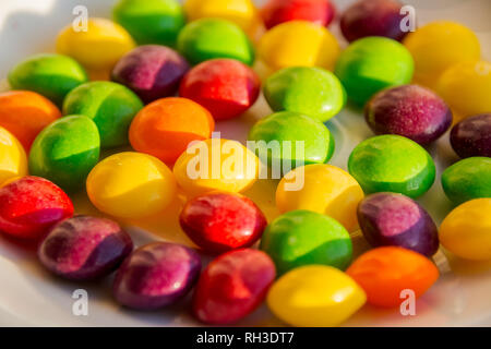 Zerstreut Dragees in verschiedenen Farben. Einen farbigen Hintergrund. Stockfoto