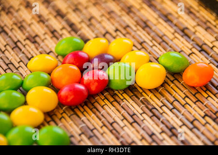 Zerstreut Dragees in verschiedenen Farben. Einen farbigen Hintergrund. Stockfoto