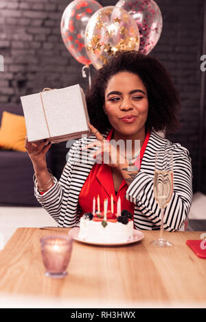 Positive fröhliche Frau schüttelte ihren Geburtstag Stockfoto