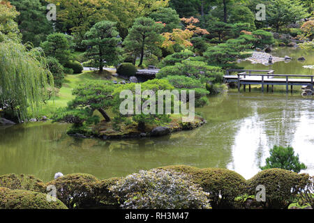 Ein japanischer Garten mit Bäumen, ein großer Teich und eine hölzerne Brücke in Seattle, Washington, USA Stockfoto