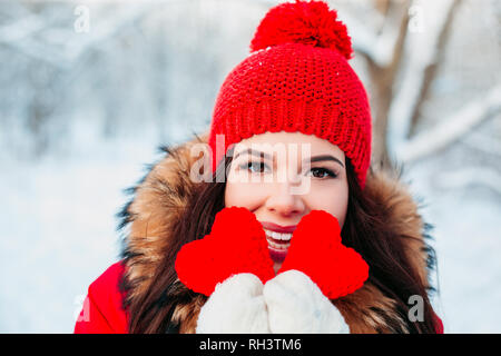 Schöne junge Frau hält ein rotes Herz in den Händen in Winter Park. Winter. Stockfoto