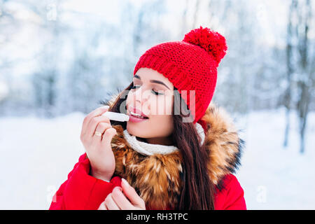 Mädchen Schutz der Lippen mit Lippenbalsam im Winter Stockfoto