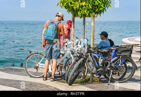 LAZISE, Gardasee, Italien - September 2018: die Gruppe der Radfahrer eine Pause an der Promenade in Lazise am Gardasee. Stockfoto