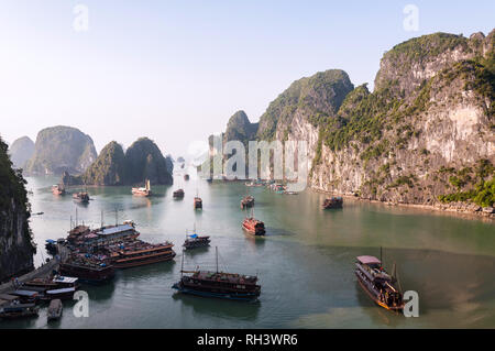 Blick von der Ausfahrt von Sung Sot Höhle Anzeigen über die Bucht von Bo Hon Insel gefüllt mit Holz- Kreuzfahrtschiffe und Kalkstein Karst, Vietnam Stockfoto