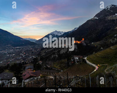 Schöne orange violett Sonnenuntergang über Meran und Schloss Tirol in Alto Adige, Italien Stockfoto