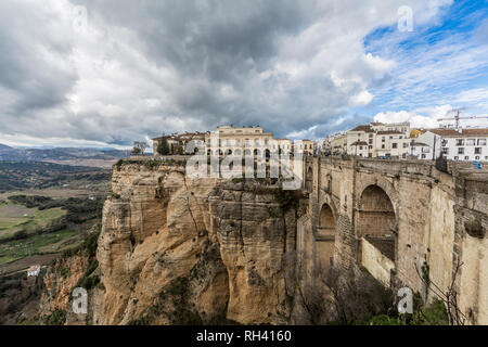 Blick auf die Stadt Ronda an der Spitze des Berges, der Tajo de Ronda und die Neue Brücke (Puente Nuevo) auf bewölkten Tag mit reichlich Wolken Stockfoto