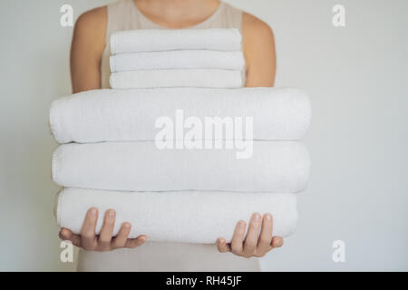 Eine Frau hält ein weißer Bettwäsche. Konzept der Service in Hotels, Wäscherei, Spa Stockfoto