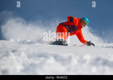 Ein Mann auf einem Snowboard machen s in den Tiefschnee in Courchevel in den Französischen Alpen. Stockfoto