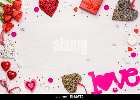 Tabelle Draufsicht Bild von Dekoration Valentinstag Hintergrund Konzept. Anordnung der künstliche rote Rosen, Herzen und Geschenk mit dekorativen Objekte auf Stockfoto