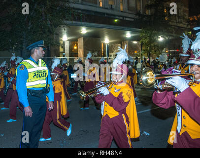 Ein Polizeioffizier Uhren eine marching band führen die Krewe von Hermes Mardi Gras Parade die St. Charles Avenue, Feb.28, 2014 in New Orleans, Louisiana. Stockfoto