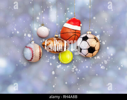 Weihnachten sport Ornamente: Baseball, Football, Basketball und Fußball hängenden Kugeln auf Schnee Hintergrund Stockfoto