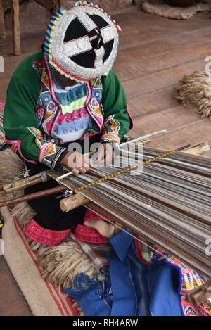 Pisac, Cusco, Peru - Oct 20, 2018: Quechua Frau zeigt traditionelle Webtechniken auf einem Markt in das Heilige Tal. Stockfoto