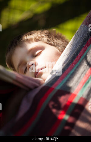Junge schlief in der Hängematte draußen in der Sonne Stockfoto