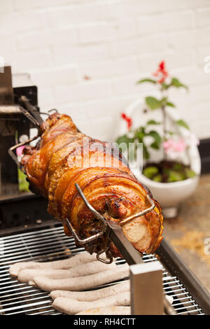 Schweinefleisch wird gebraten auf Spucken in englischer Pub. Stockfoto