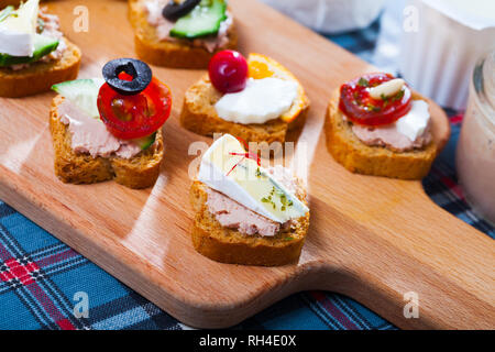 Verschiedene frisch zubereitete Kanapees mit Fleisch, Pasteten, Käse, Gemüse Stockfoto