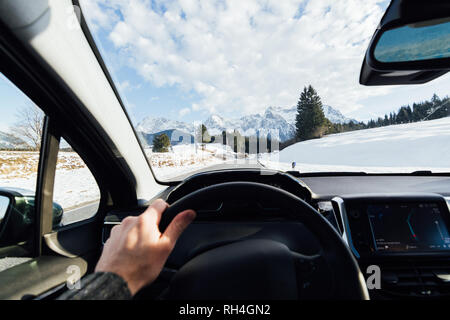 Blick aus der Auto fahrer Sitz über Winter Alpine Road in Richtung Berge in Österreich Stockfoto