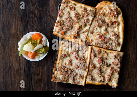 Türkisch und Arabisch traditionellen Ramadan Brot geschnitten Etli Ekmek Kebab mit Hackfleisch (Pide oder Lahmacun Kebap) dienen auf Holz von Konya und Kayseri Stockfoto