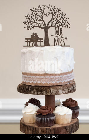 Hochzeitstorte & Schokolade Vanilla Cupcakes als Dessert bei einem rustikalen Themenempfang serviert Stockfoto