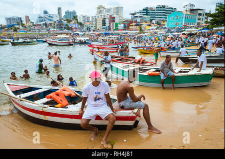 SALVADOR, Brasilien - Februar 02, 2016: Fischer im Dorf Rio Vermelho ihren Fischerbooten bieten zu Feiernden auf dem Festival von yemanja. Stockfoto