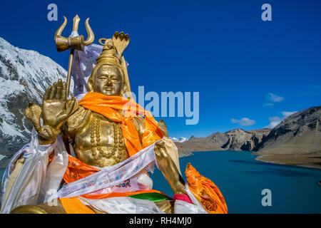 Golden Shiva Statue, Panoramablick auf Tilicho See und den verschneiten Hängen des Tilicho Peak in der Ferne Stockfoto