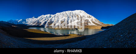 Panoramablick über Tilicho See, die schneebedeckten Gipfel der Kangsar Kang und Tilicho Peak Spiegelung, bei Sonnenaufgang Stockfoto