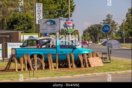 Johannesburg, Südafrika - Unbekannter am Straßenrand Verkäufer verkauft Gras für Dach thatching auf einer Straße Ecke Bild im Querformat. Stockfoto