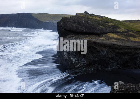 Schwarzer Strand und Felsen in der Nähe von Vik Stadt im südlichen Island. Stockfoto