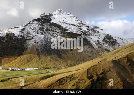 Ein Berg mit ersten Herbst Schnee in Skógafoss im südlichen Island abgedeckt. Stockfoto