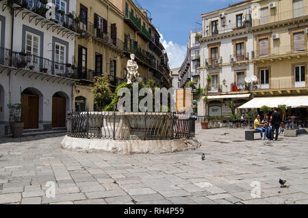 PALERMO, ITALIEN, 15. JUNI 2018: Anwohner und Tauben in der Sonne auf der Piazza Rivoluzione in der Altstadt Palermos entfernt. Der Brunnen wird gekrönt Stockfoto