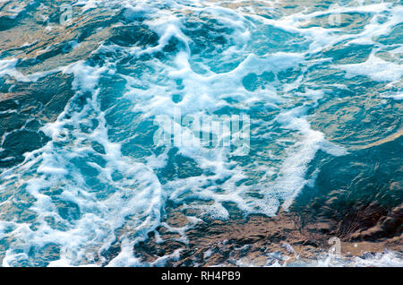 Schäumende Wasser Wellen am Meer, Ansicht von oben. Top Meerblick Textur. Foto mit Bewegungsunschärfe. Stockfoto