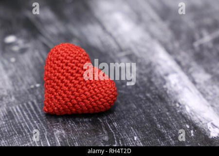 Rot gestrickt Herz auf vintage Holz- Hintergrund. Valentine Herz, Symbol der romantischen Liebe, Blutspende, Gesundheitswesen Stockfoto