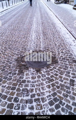 Kommunale Kanaldeckel anv Blick auf gepflasterten Straße und die Große Waffenkammer, 1609, Akademie der Bildenden Künste, Ulica Piwna, Danzig, Polen Stockfoto