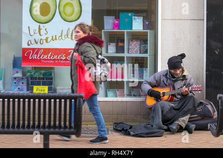 Obdachlose Gaukler mit Gitarre, Musik, Musiker, Straße, Instrument, Spielen, Mann, Performer, Künstler, Musik, Unterhaltung, männliche Gitarrist, Stadt, Player, Sound, Art, urban, akustische, allein auf den Straßen von Blackpool Großbritannien Stockfoto