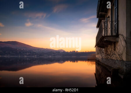 Berge wider nach Sonnenuntergang im See von Annone, Lombardei, Italien Stockfoto