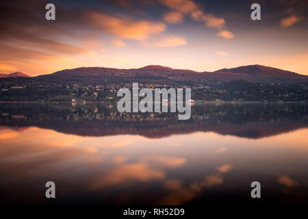 Berge wider nach Sonnenuntergang im See von Annone, Lombardei, Italien Stockfoto