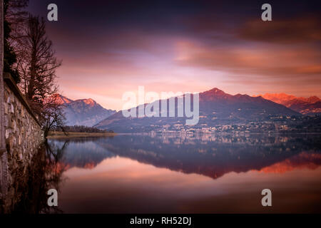 Berge wider nach Sonnenuntergang im See von Annone, Lombardei, Italien Stockfoto