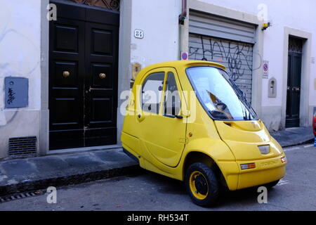 Kleine gelbe Pasquali Riscio Produktion Auto vor grafitti Metall Garagentor Florenz Italien geparkt Stockfoto