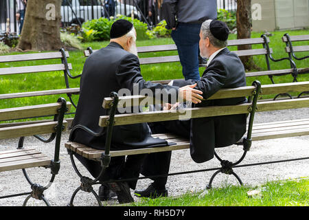 Zwei jüdische Männer mit kippa zu sprechen in einer öffentlichen Bank im Finanzdistrikt von New York Stockfoto