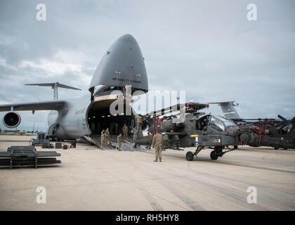 190130-N-TR 141-0034 NAVAL STATION Rota, Spanien (Januar 30, 2019) Soldaten der 1. Gepanzerten Division und 1109Th Theater Luftfahrt Sustainment Instandhaltungsgruppe zugeordnet ein AH-60 Apache Helikopter auf einem C-5 Flugzeugs für den Kombinierten Verkehr. Intermodale Operationen kombinieren, zu Wasser und in der Luft cargo handling zu verringern, die Sicherheit zu verbessern, Schäden zu minimieren und schneller Transport ermöglichen. (U.S. Marine Foto von Mass Communication Specialist 1. Klasse Benjamin A. Lewis) Stockfoto