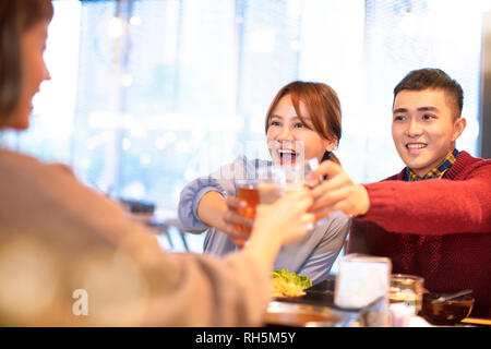 Gerne jungen Menschen Freunde Toasten und Essen im Restaurant Stockfoto