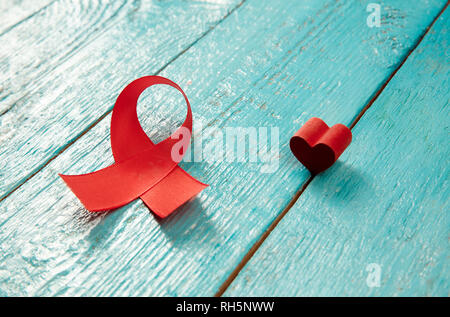 Aids-Aufklärung Zeichen rote Bänder auf Blau Holz- Hintergrund. Welt-AIDS-Tag Konzept. Die Gesundheit, Hilfe, Pflege, Support, Hoffnung, Krankheit, Gesundheitswesen Konzept Stockfoto