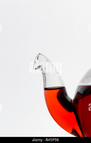 Die Nase in der Nähe von Glas Transparenz Teekanne mit roter Hibiskus Tee auf weißem Hintergrund Stockfoto