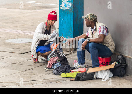 Durban, Südafrika - Januar 6th, 2019: Zwei Männer Handel Kleidung auf der Straße in einer Ecke der City Centre in Durban, Südafrika. Stockfoto