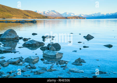 Lake Tekapo sunsise über felsige Küste und niedrigem Wasserstand der Ruhe ruhige See Stockfoto