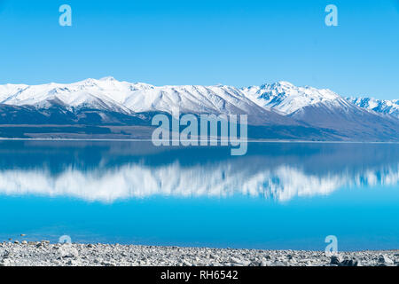 Die schneebedeckten Berge, in einer ruhigen malerischen Lake Pukaki in Mackenzie Basin Canterbury, NZ wider Stockfoto