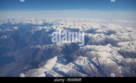 Antenne Landschaft der Alpen in Europa während der Wintersaison mit frischem Schnee. Blick aus dem Fenster des Flugzeuges Stockfoto