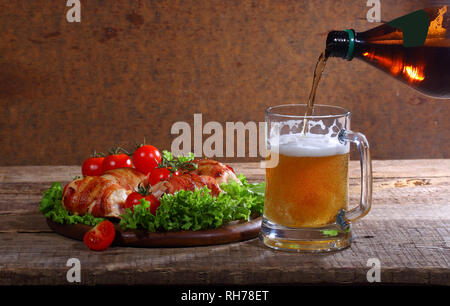 Bier mit Fried Chicken rollt auf einem Holztisch Stockfoto