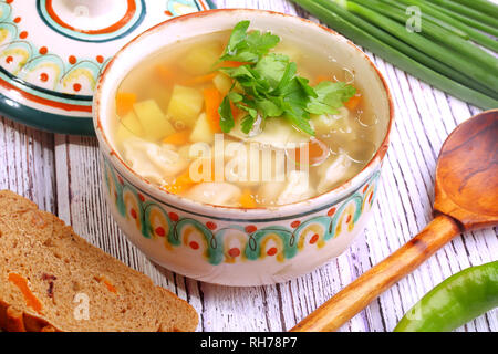 Gemüsesuppe mit Knödeln auf einem Holztisch Stockfoto