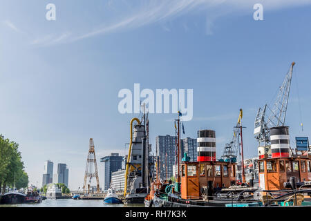 Frachtschiffe mit Orange, Schwarz und Rot in den Wijnhaven Harbour im Zentrum von Rotterdam in den Niederlanden Holland verankert Stockfoto